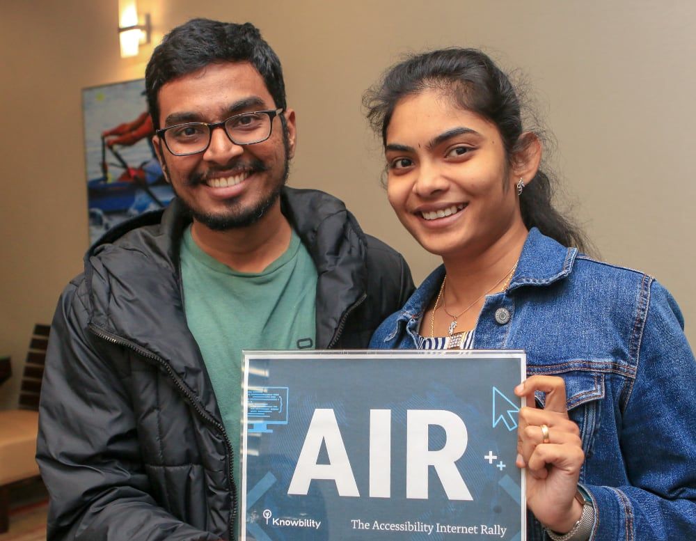 Two young people holding an AIR sign.